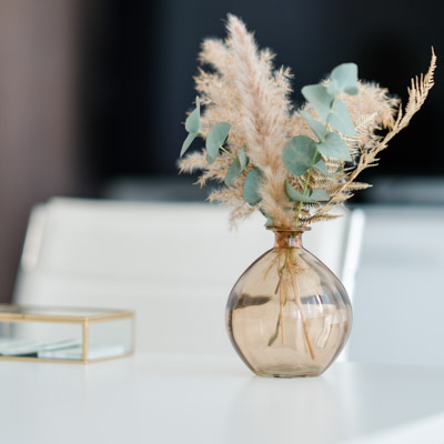 Detailaufnahme Vase mit Trockenblumen – steht für Ruhe, Sorgfalt und Stil im Arbeitsumfeld
