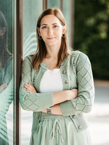 Porträt von Kröll Katharina einer Mitarbeiterin der Südsteirischen Steuerberatung – freundlich, professionell, vor Glasfassade stehend