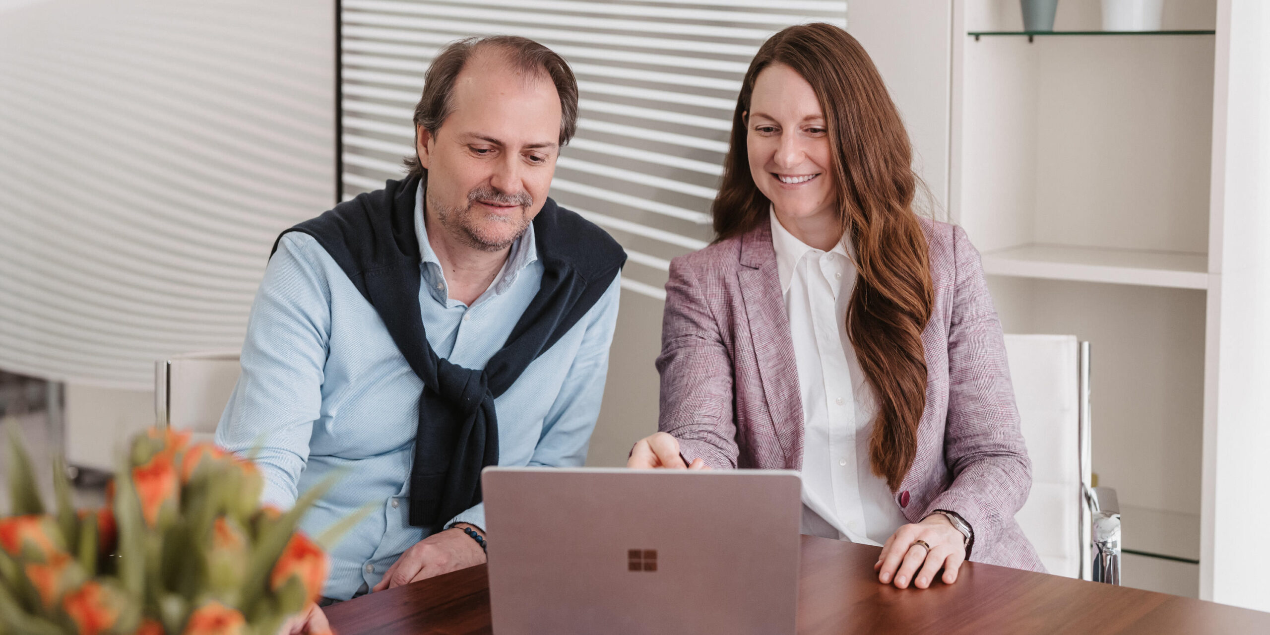Steuerberater und Mitarbeiterin arbeiten gemeinsam am Laptop